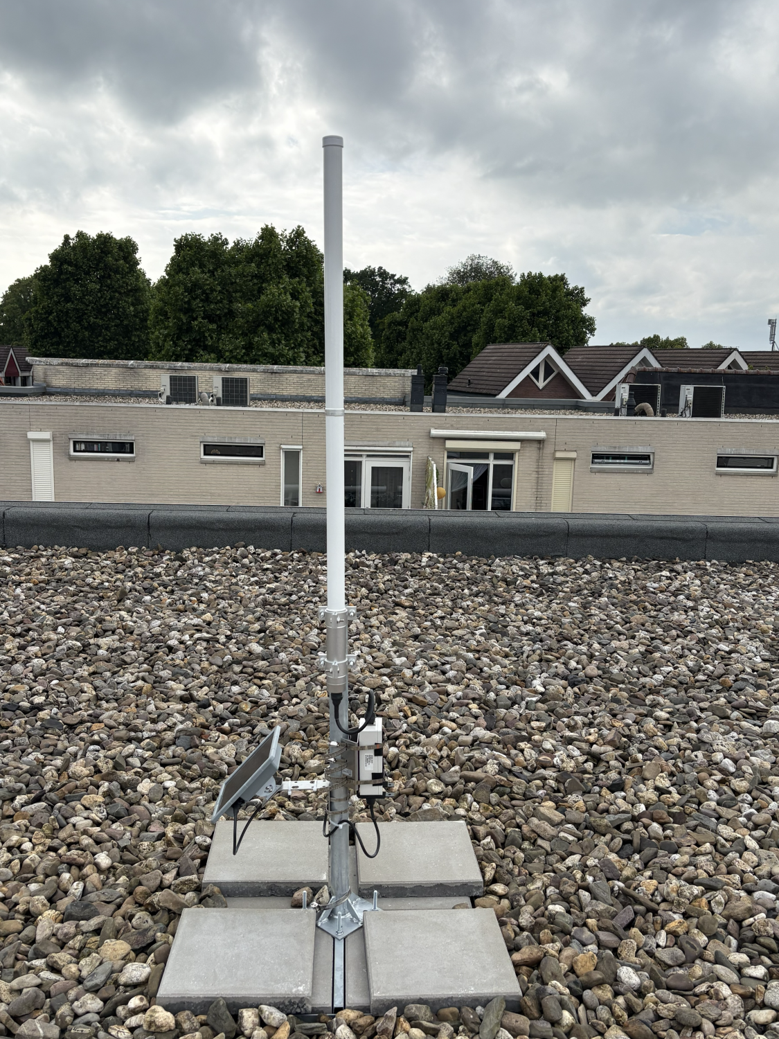 The rooftop MeshCore setup with its SenseCAP P1 Pro, McGill antenna, and ballasted mast